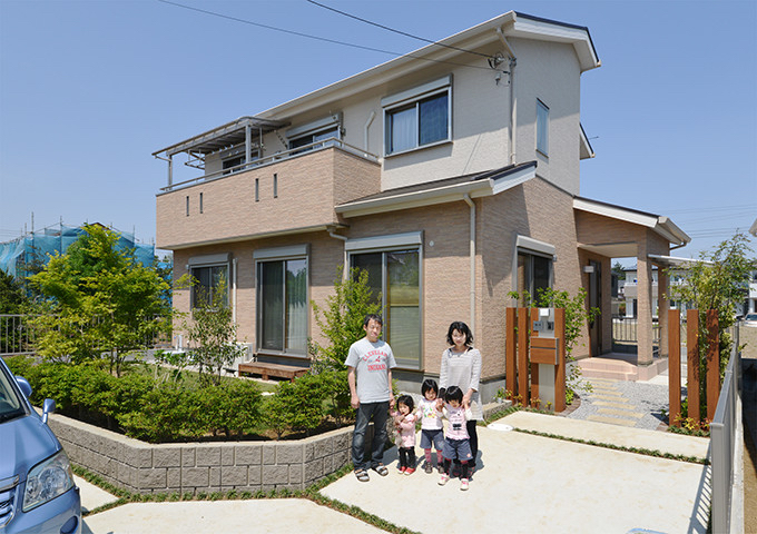 川木建設（川越市）で建てた家の全景写真です。女性設計士の久保茜が設計をしました。お施主様ご夫妻と、３人のお子様と、家の前での撮影